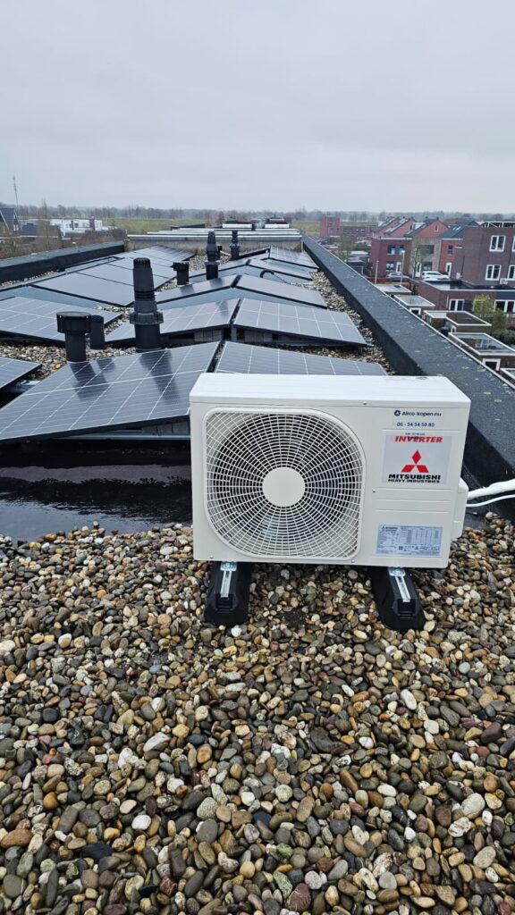Buitenunit met zonnepanelen op de achtergrond – praktische plek, vrij van obstakels.