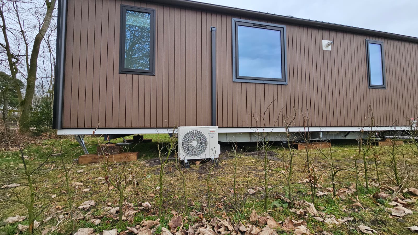 Buitenunit Tosot CLIVIA geplaatst bij het chalet – netjes op dempers