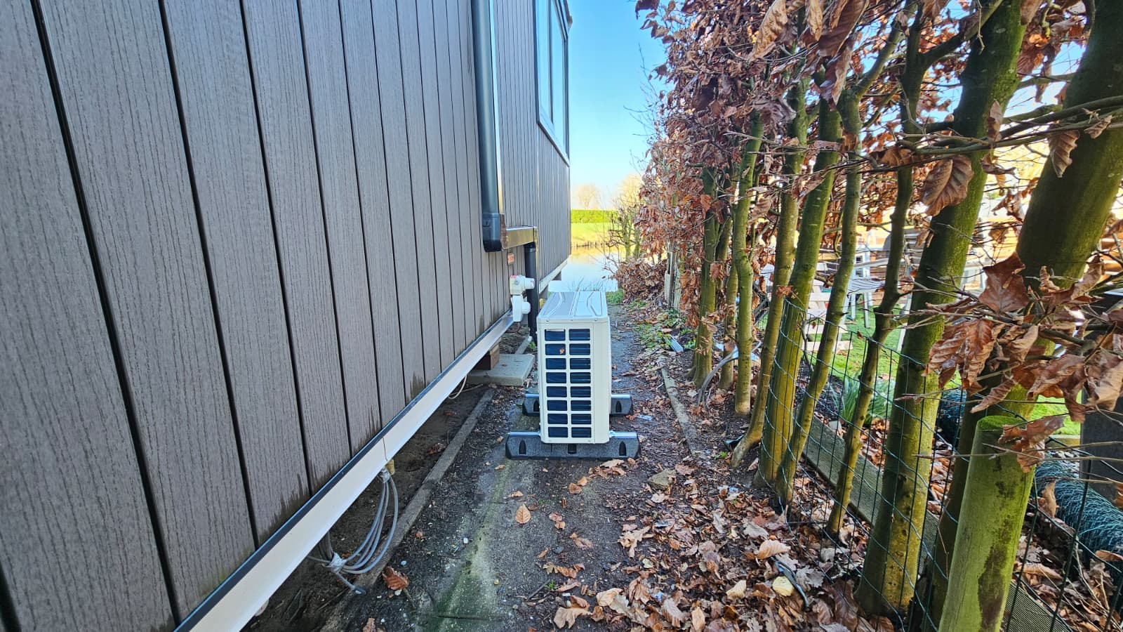 Buitenunit van Tosot Clivia White airco geplaatst naast verhuur chalet in de Betuwe