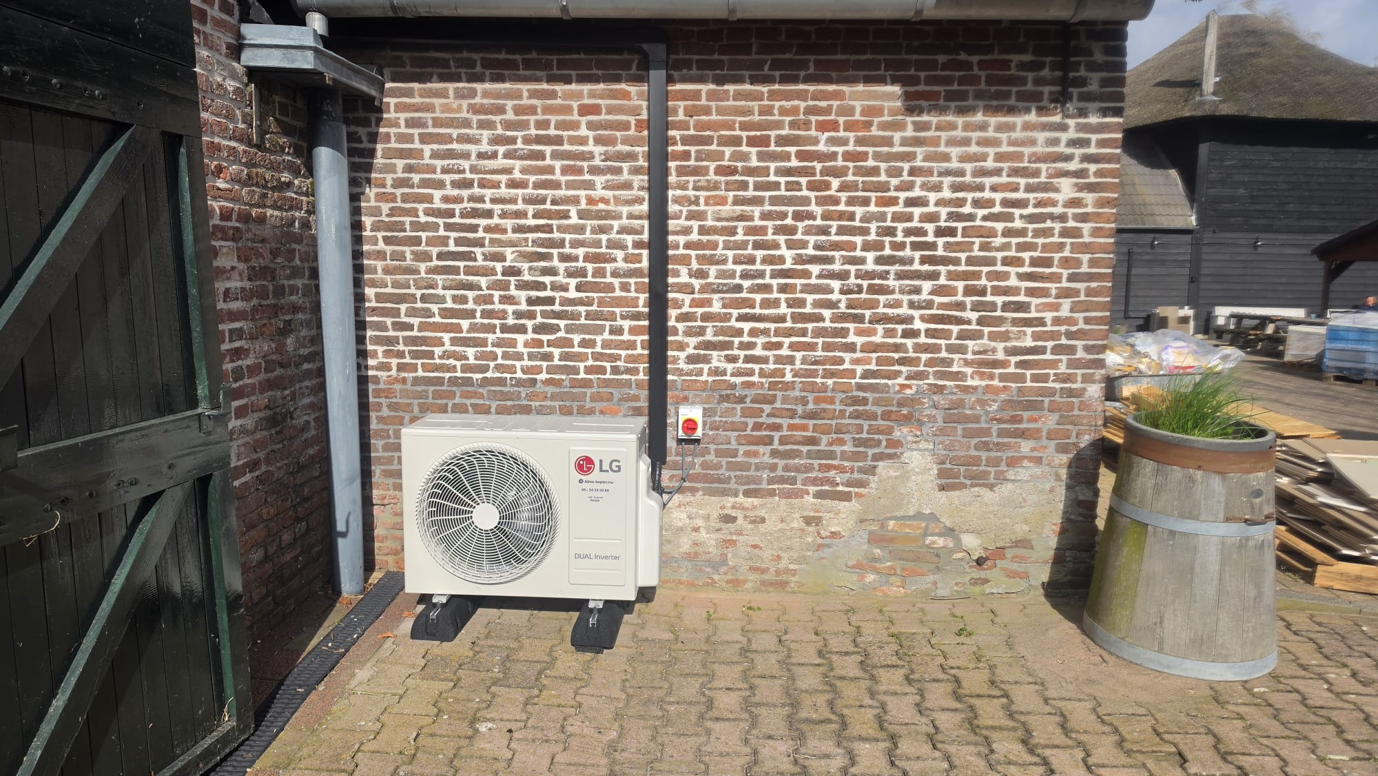 Close-up van LG DUALCOOL DELUXE buitenunit bij woonboerderij in Erichem