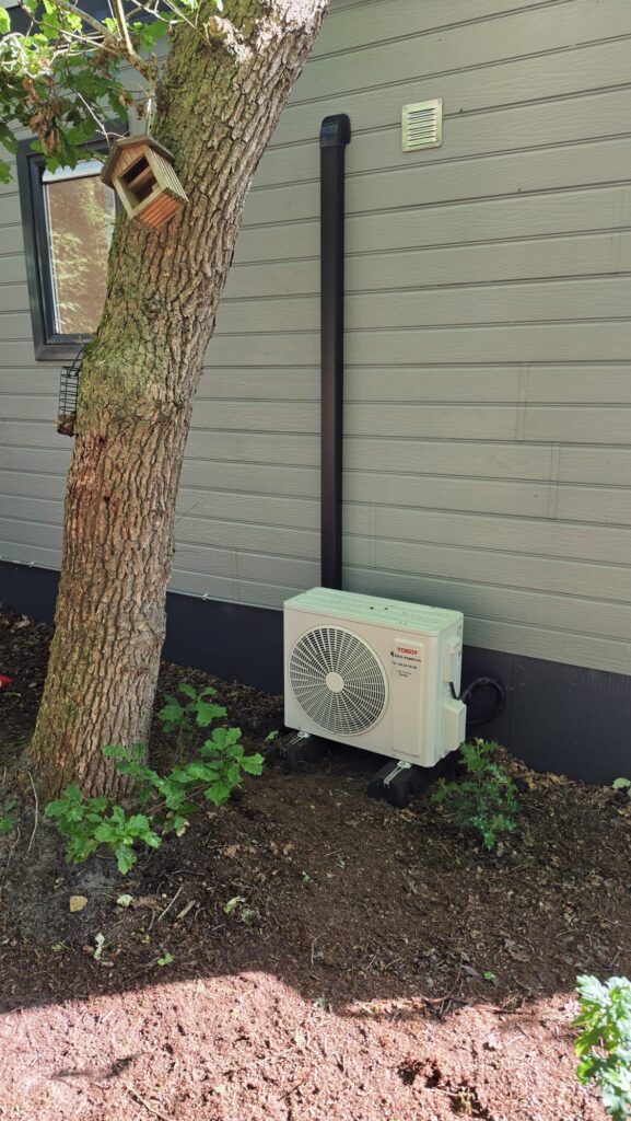 Tosot CLIVIA by GREE buitenunit naast chalet op Camping Ommerland in Ommen geplaatst op rubberen geluiddempende blokken