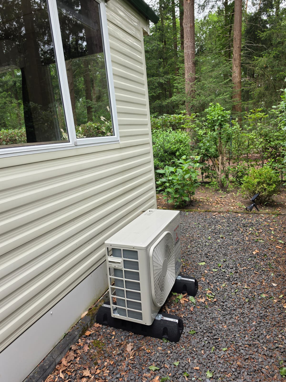 Airco buitenunit naast chalet op Camping Samoza in bosrijke omgeving van Vierhouten