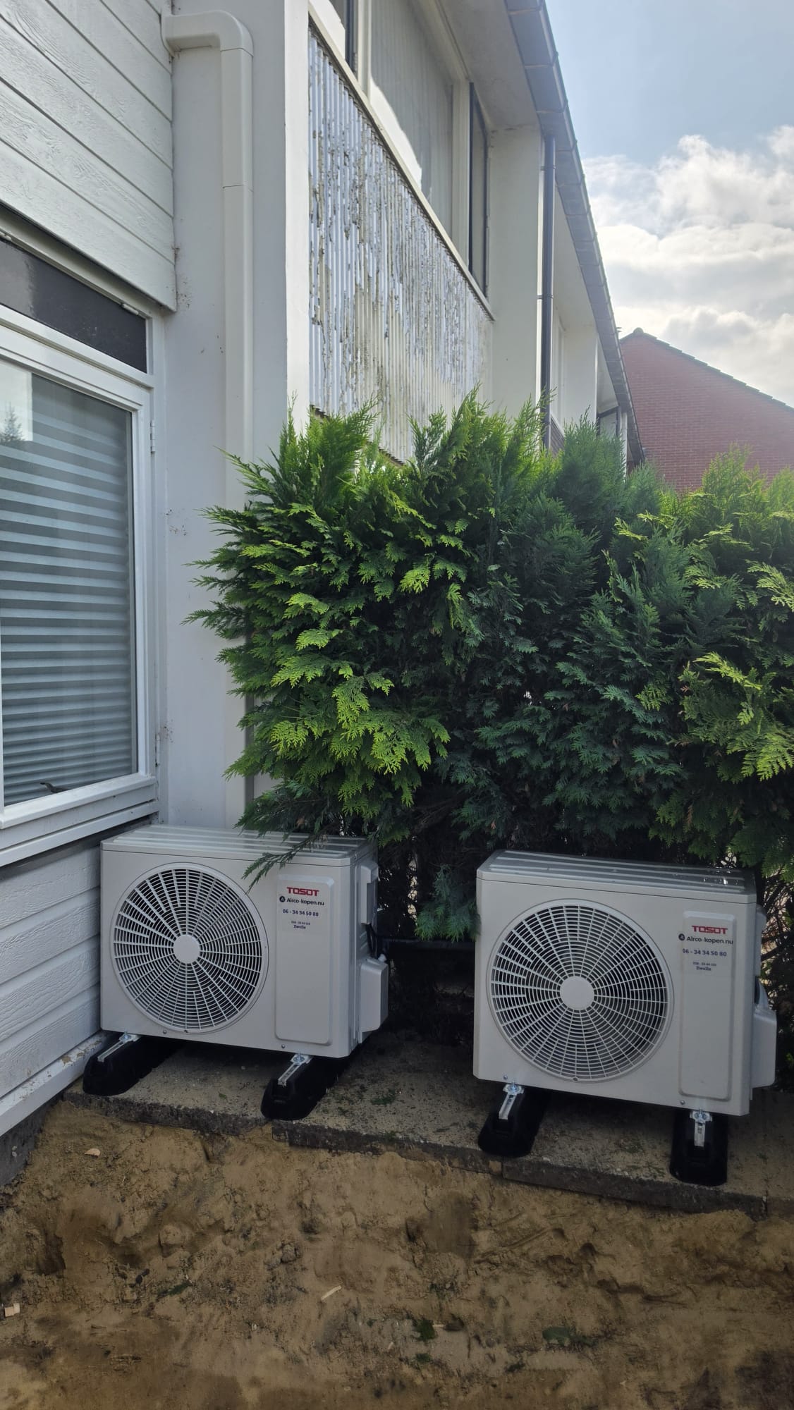 Twee Tosot CLIVIA buitenunits naast elkaar geplaatst in voortuin in Klazienaveen op rubberen blokken