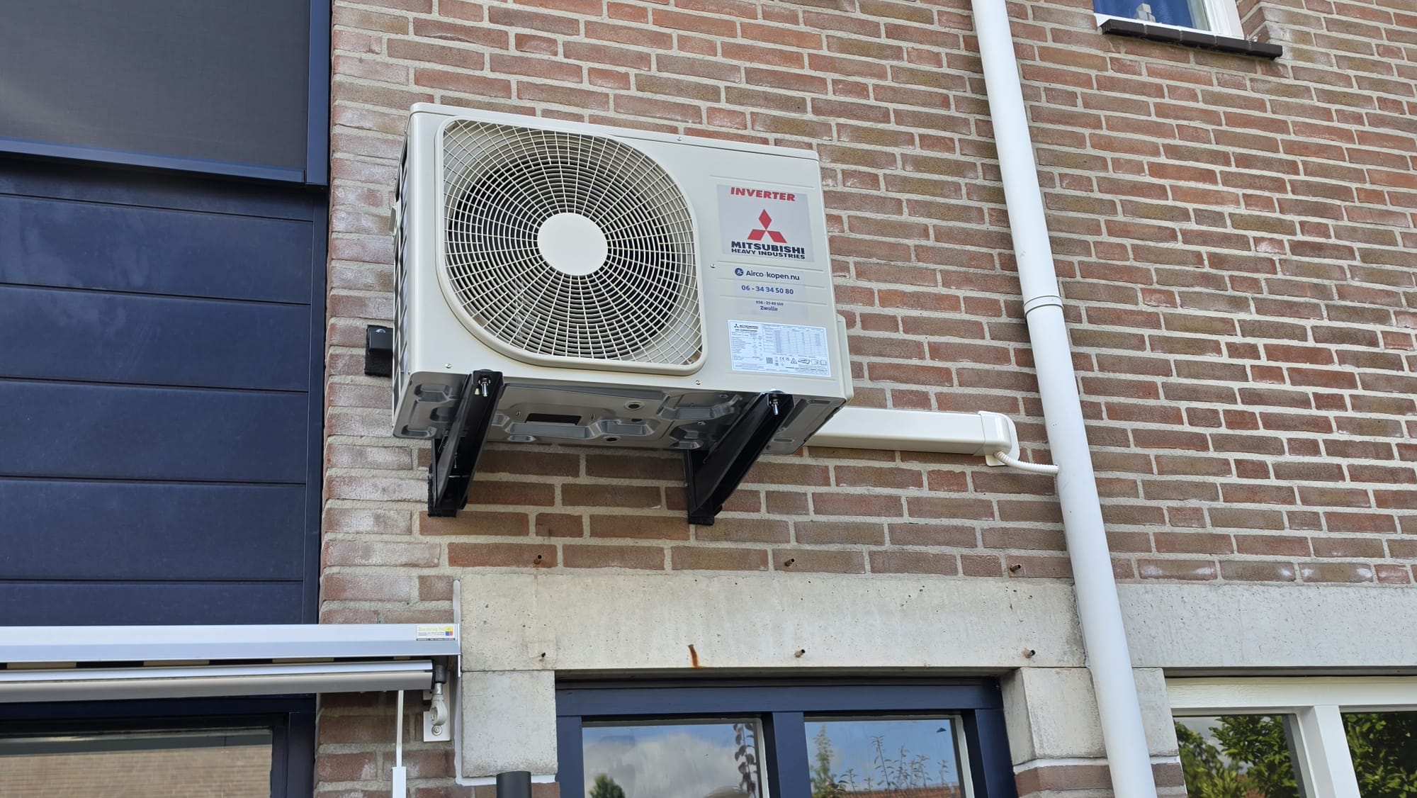 Mitsubishi Heavy Industries buitenunit op muurbeugels aan voorzijde woning in Zwolle-Zuid