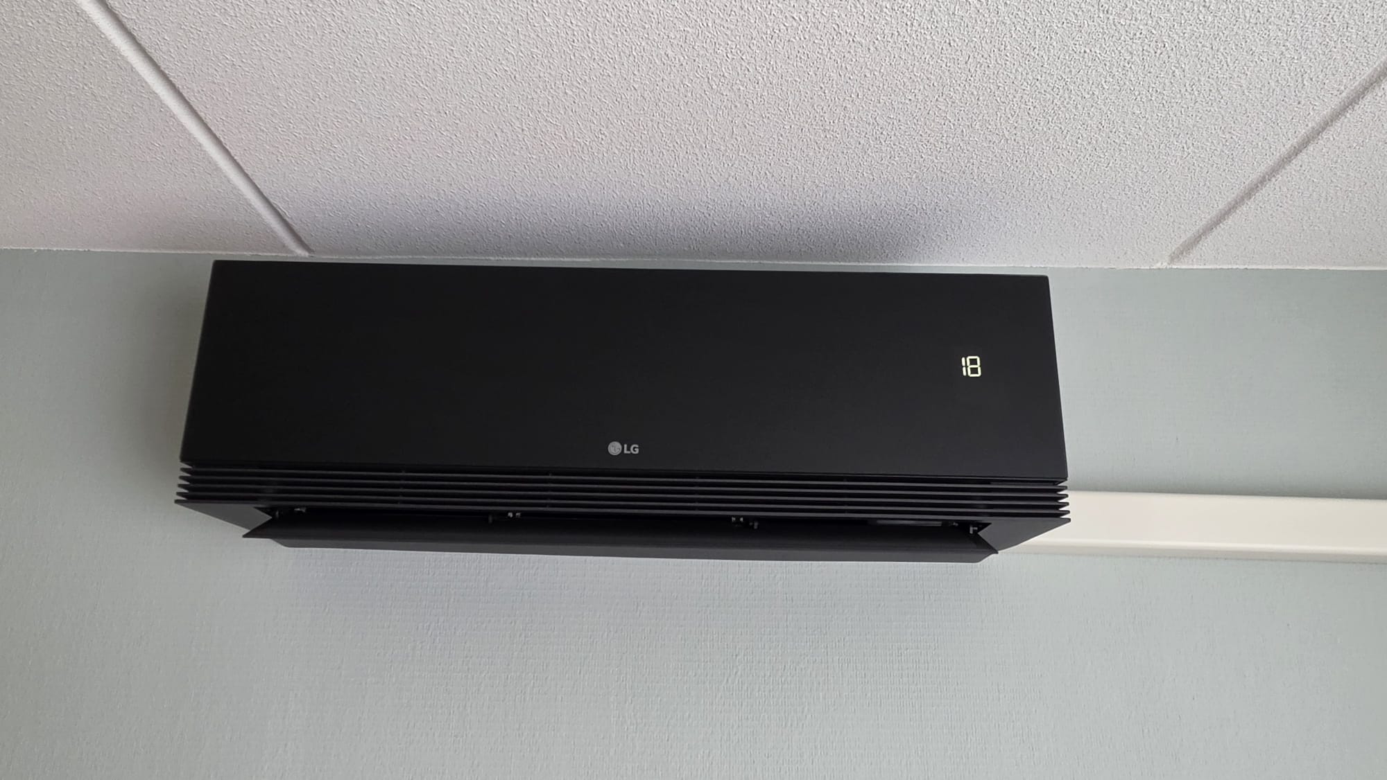 Close-up van mat-zwarte LG ARTCOOL AI AIR binnenunit in woonkamer